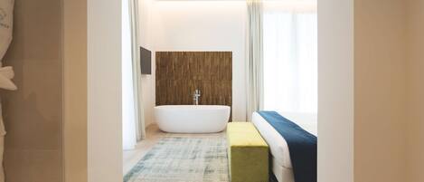 A modern bathroom with a freestanding bathtub, a wooden accent wall, and a large window providing natural light.