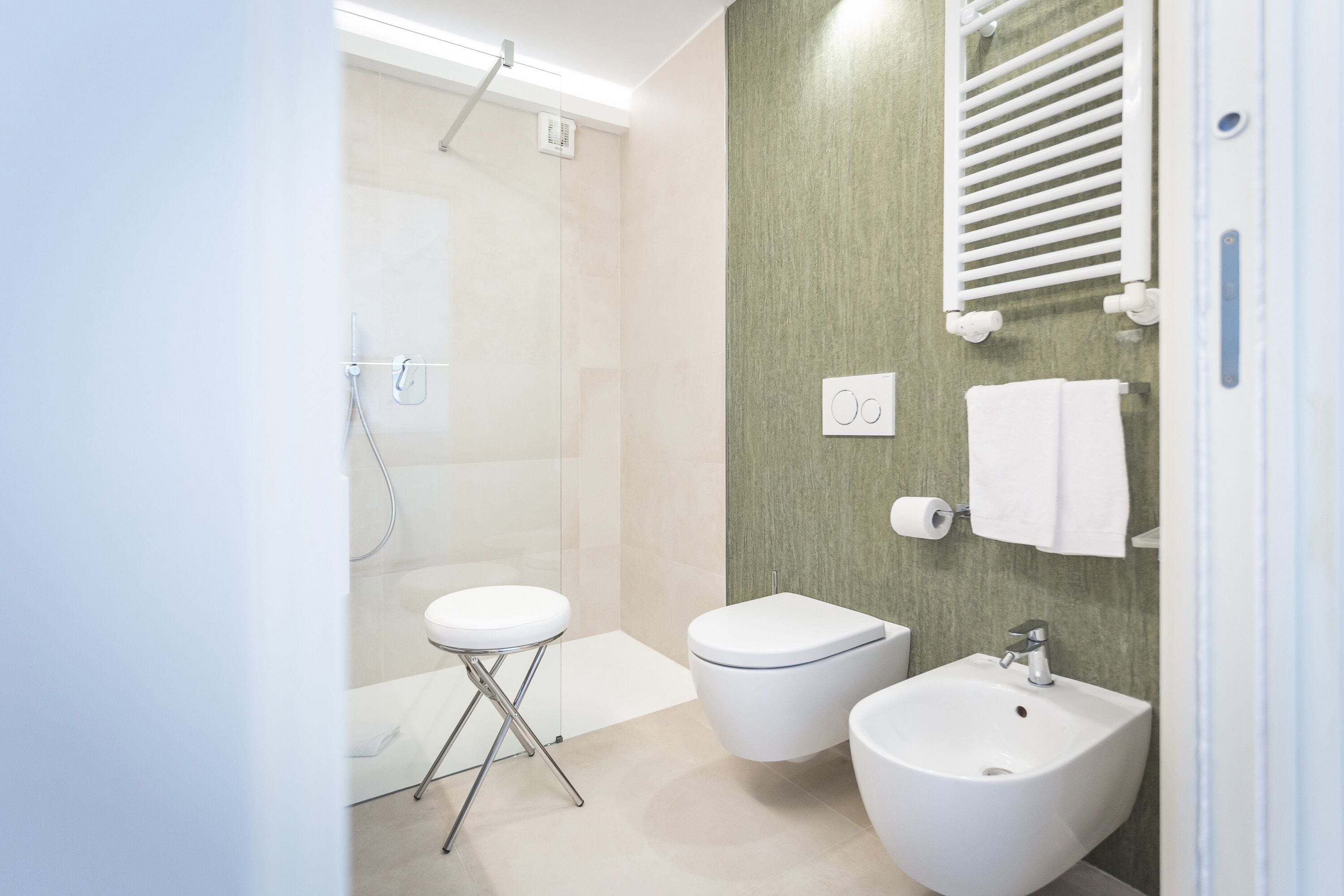 Ein modernes Badezimmer mit Dusche, Toilette, Bidet und Waschbecken.