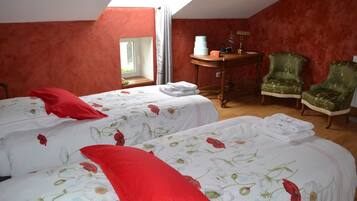 A room with two beds, a table, and two chairs.