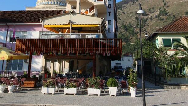 A hotel with a dome structure, outdoor seating area, and a hillside backdrop. - Hotel Orestiada (Velabisht)