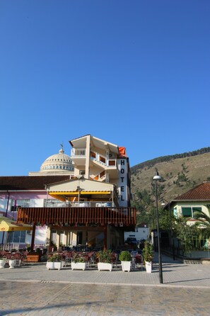Un hotel con estructura en forma de cúpula, zona de estar al aire libre y un paisaje montañoso de fondo.