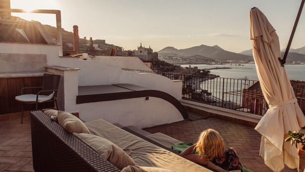 A rooftop terrace with a sofa, a chair, and a table. - B&B L'Ambasciata (Gaeta)