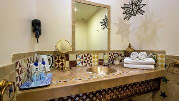 A bathroom with a sink, mirror, towel rack, and decorative star-shaped lights.
