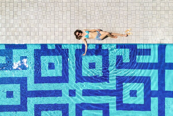A person lying on a patterned pool floor. - Finca Aal Cachucho Hotel Rural (San Agustin del Guadalix)