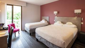 Habitación de hotel con dos camas, un escritorio, una silla y un balcón con vistas.