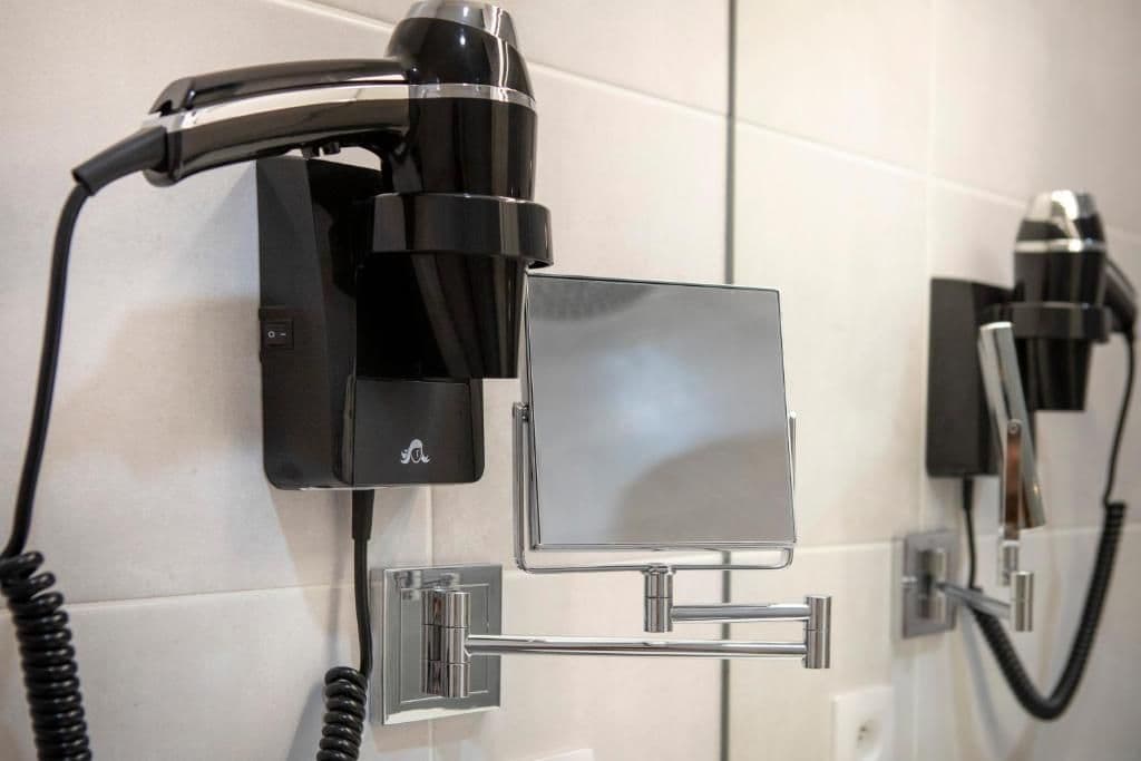 En væghængt hårtørrer med kontrolpanel og metalstativ.