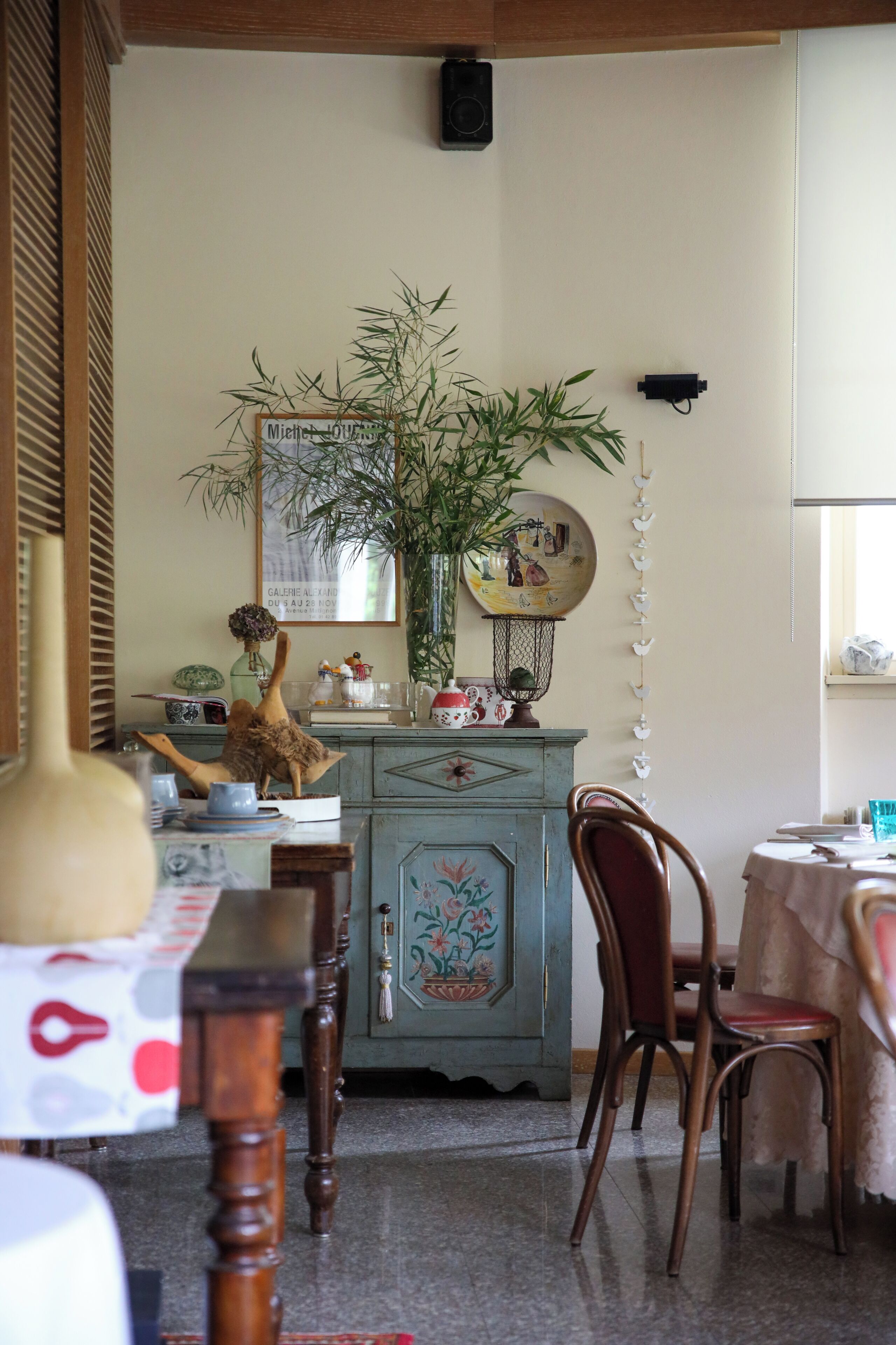 A dining area with a wooden table, chairs, and a cabinet with decorative items.