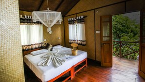 A bedroom with a bed, a mosquito net, and a balcony with a view of trees. - Thick forest sigiriya (Sigiriya)