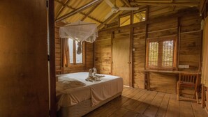 A wooden cabin room with a bed, a desk, and a chair. - Thick forest sigiriya (Sigiriya)
