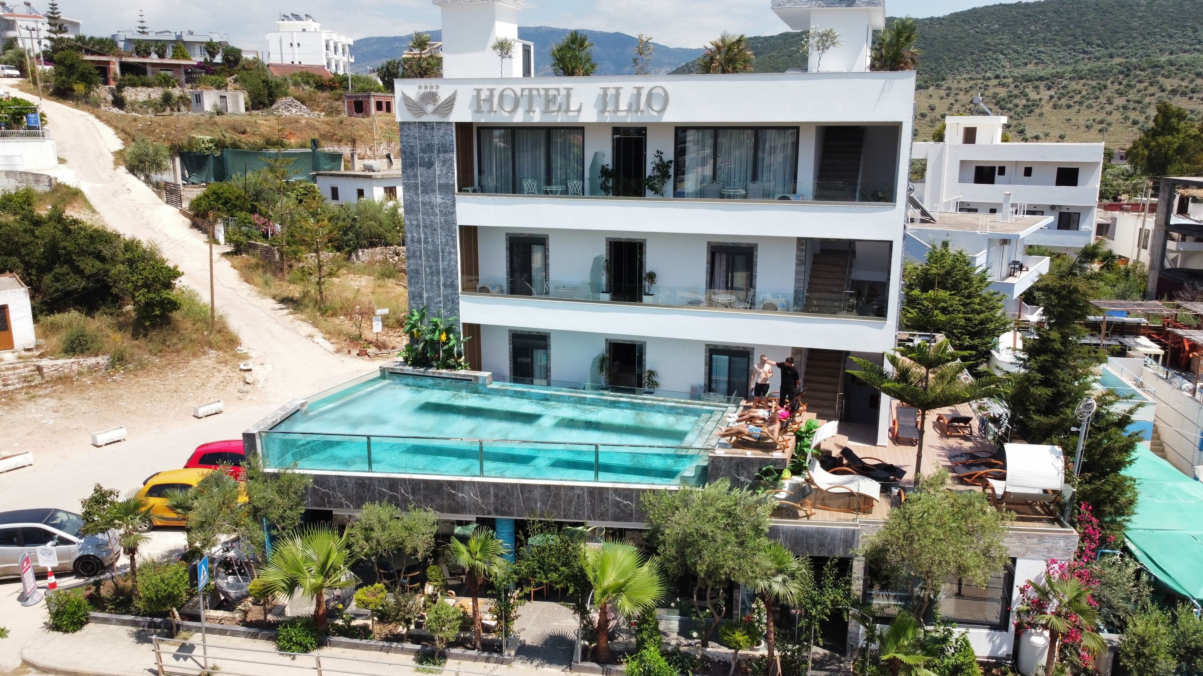 Un hotel moderno con piscina, varios pisos y vistas al paisaje circundante.