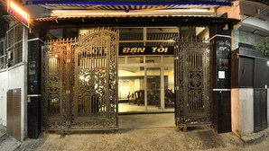 A hotel entrance with ornate metal gates and a sign that reads "BAW TÖI".