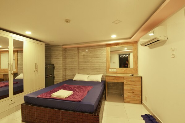 Quarto com cama, guarda-roupa, cômoda e espelho.
