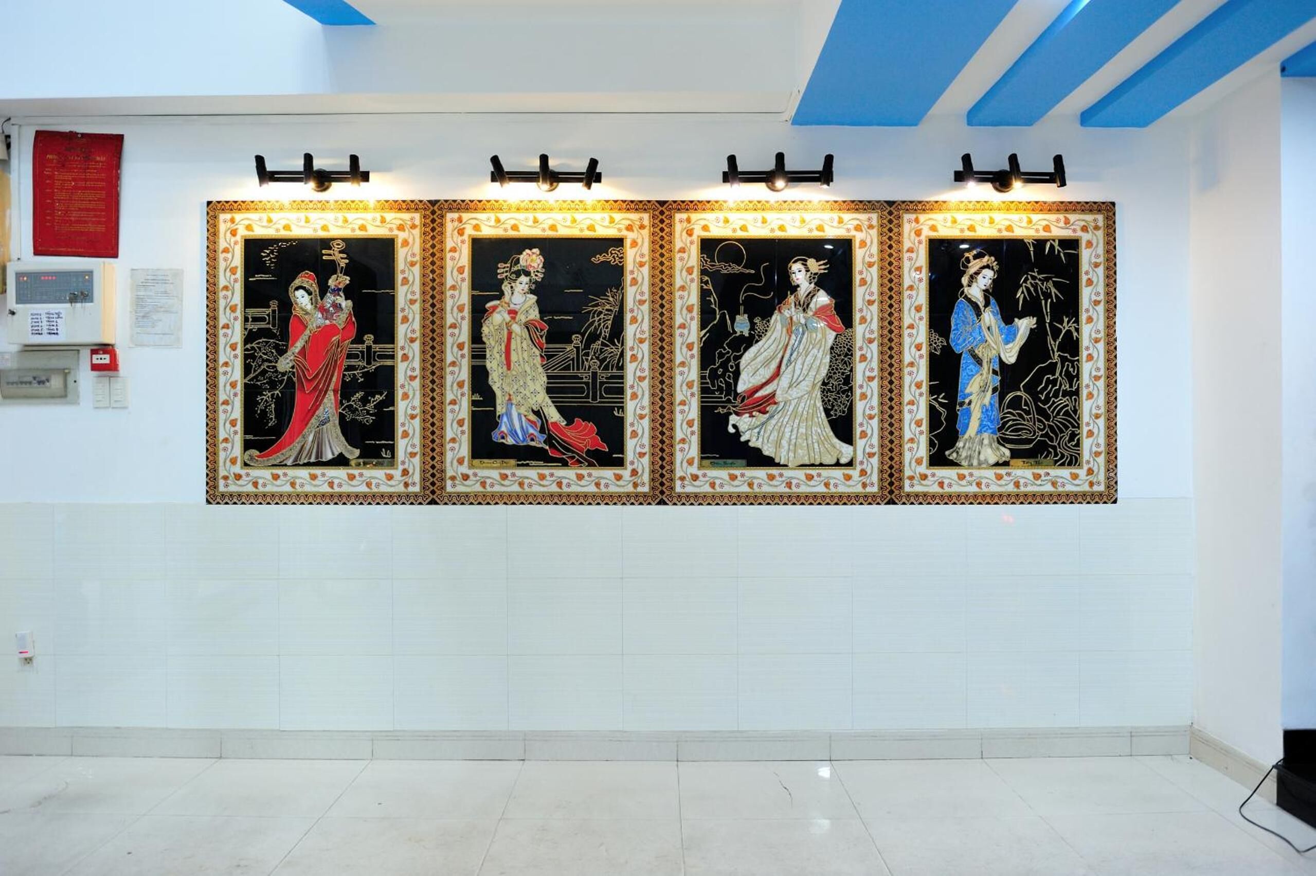 A wall with four framed artworks depicting figures in traditional attire.