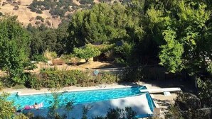 Une piscine offrant une vue dégagée sur le paysage environnant, notamment sur les collines et les arbres.