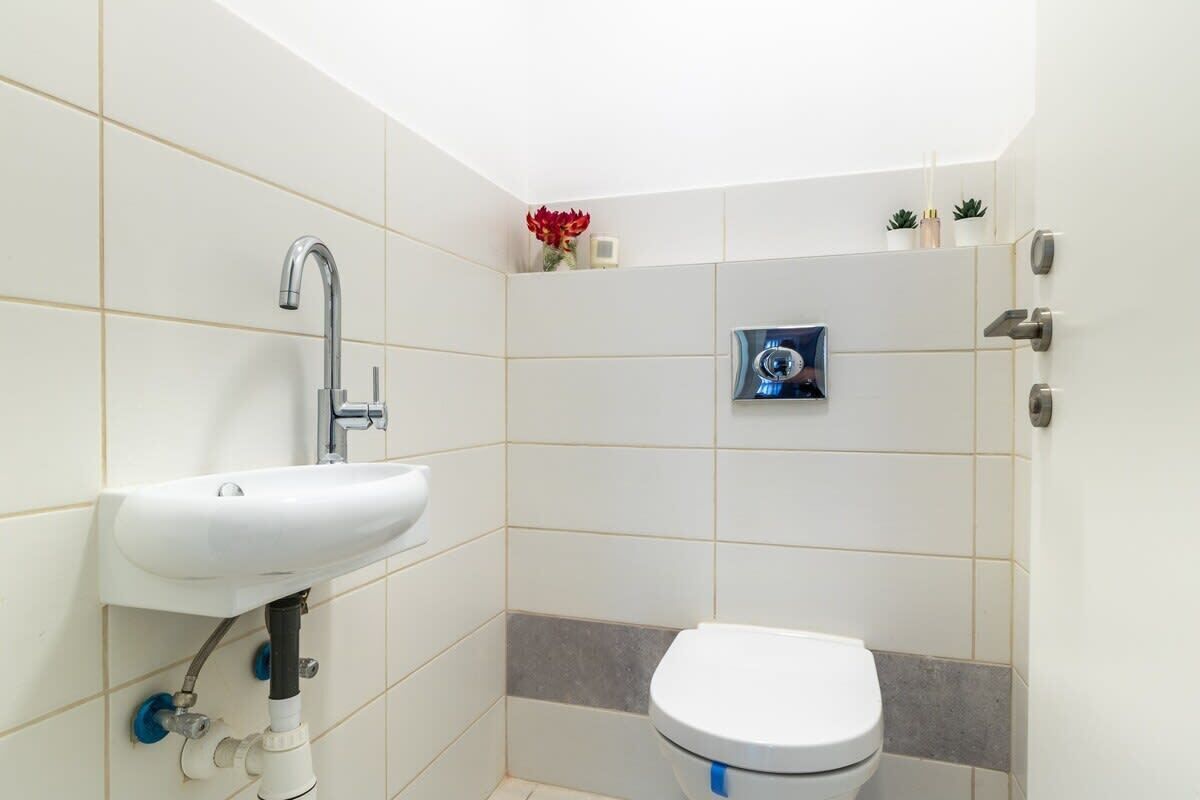 Une petite salle de bain avec un lavabo blanc, des toilettes et un espace douche.