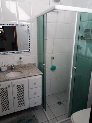 Ein Badezimmer mit Waschbecken, Spiegel und Dusche.