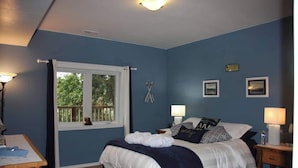 A bedroom with a bed, two bedside tables, a window with a view, and a door. - Lakeside Living Suite! ~Mt. Rainier, NWTrek, JBLM (Graham)