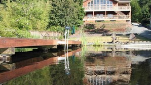 A lodge with a large deck and a pond in front. - Lakeside Living Suite! ~Mt. Rainier, NWTrek, JBLM (Graham)