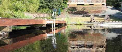 Uma pousada com um deck amplo e um lago em frente.