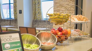 A buffet with fruits, vegetables, and pastries. There is a sign indicating an excellent food safety rating. - Snoqualmie Inn by Hotel America (Snoqualmie)