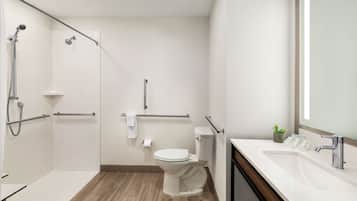 Een moderne badkamer met een douche, toilet en wastafel.