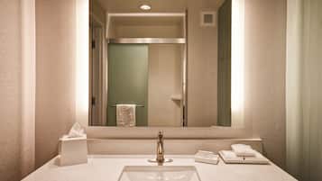 A modern bathroom with a large mirror, a sink, and a towel rack.