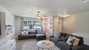 A modern living room with two sofas, a coffee table, and a ceiling fan. - 4 bedroom house near, 15 min from Magnolia (Waco)