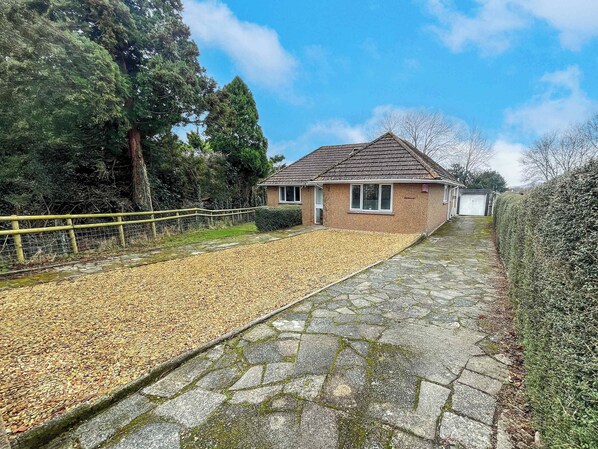 A house with a paved driveway leading to a garage.