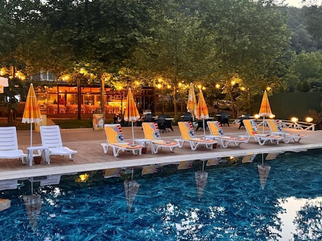 Una piscina al aire libre de temporada, sombrillas