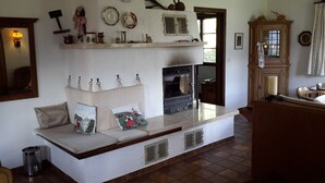 A cozy kitchen with a built-in oven, a wooden cabinet, and a bench with cushions.