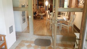 A room with a dining table, chairs, and a door leading to another room. - Romantic located, historic water mill in Silberbachtal (Horn-Bad Meinberg)