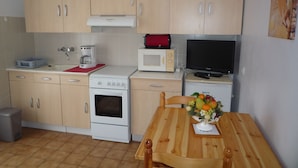 A compact kitchen with a stove, microwave, and a small TV. - apartment F1,1 room, 1 kitchen, 1 bathroom possibility 4 pers. (Vescovato)