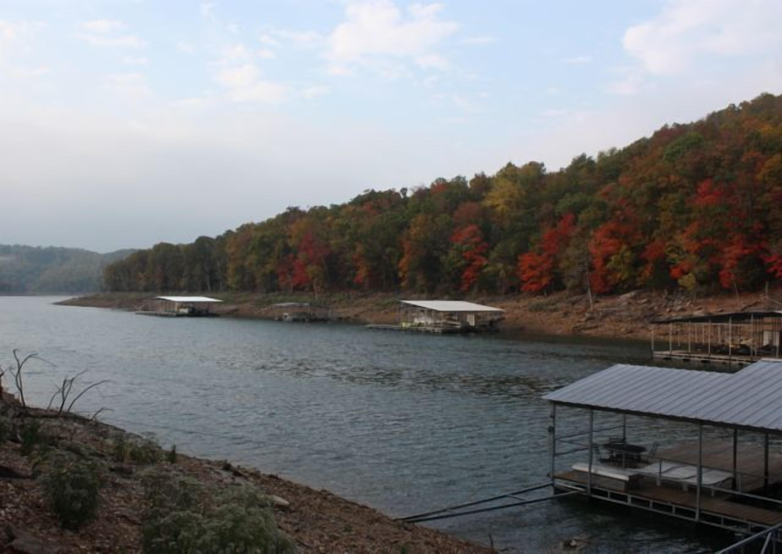 A lakeside view with docked boats and a covered area with seating.