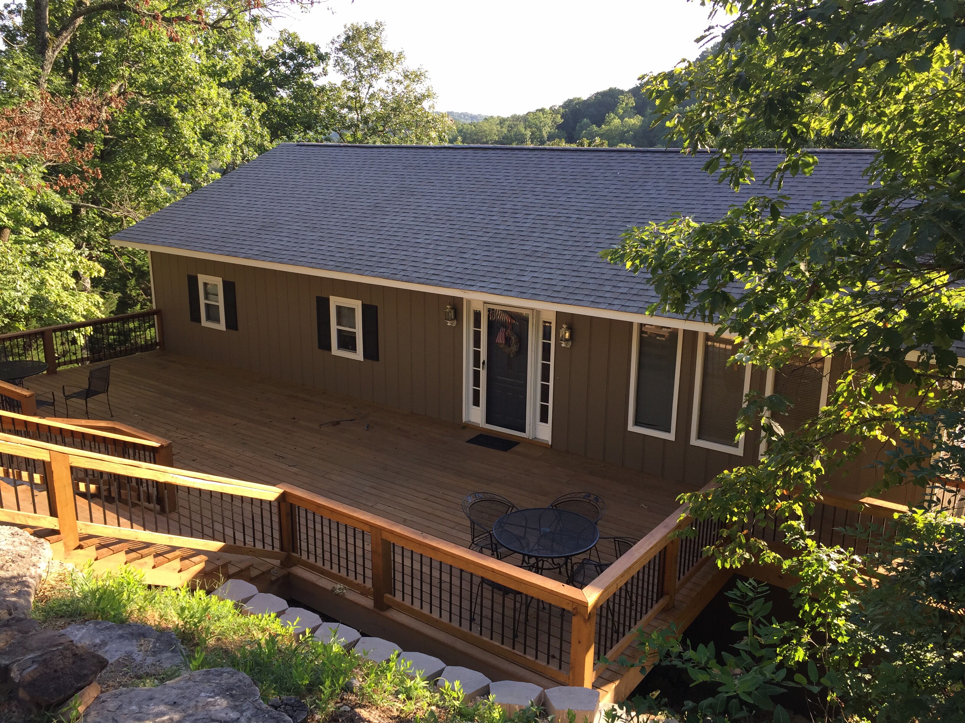 A wooden deck with a railing, a door, and a window.