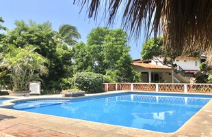 Una piscina al aire libre, sillones reclinables de piscina