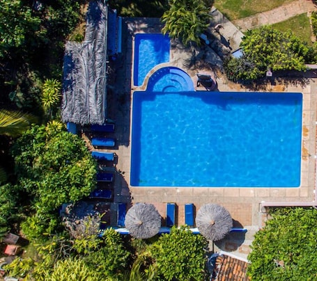Una piscina al aire libre, sillones reclinables de piscina