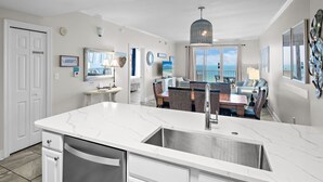 A modern kitchen with a large island, a dining area with a view, and a living space with a balcony. - ☀️By Beach in Seascape-Fabulous 19th FL Gulf Views-3BR Ariel Dunes II 1909☀️ (Destin)