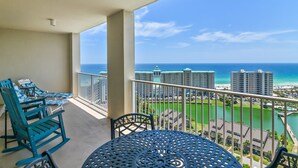A balcony with a view of the ocean, a table, and two rocking chairs. - ☀️By Beach in Seascape-Fabulous 19th FL Gulf Views-3BR Ariel Dunes II 1909☀️ (Destin)