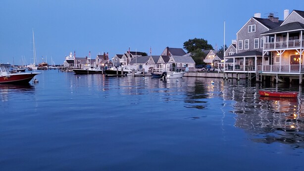 A waterfront marina with docked boats, waterfront houses, and a pier with a boat named "Bantucket." - OCEAN VIEWS! Immaculate Quintessential Nantucket Beach Cottage see virtual tour. (Nantucket)