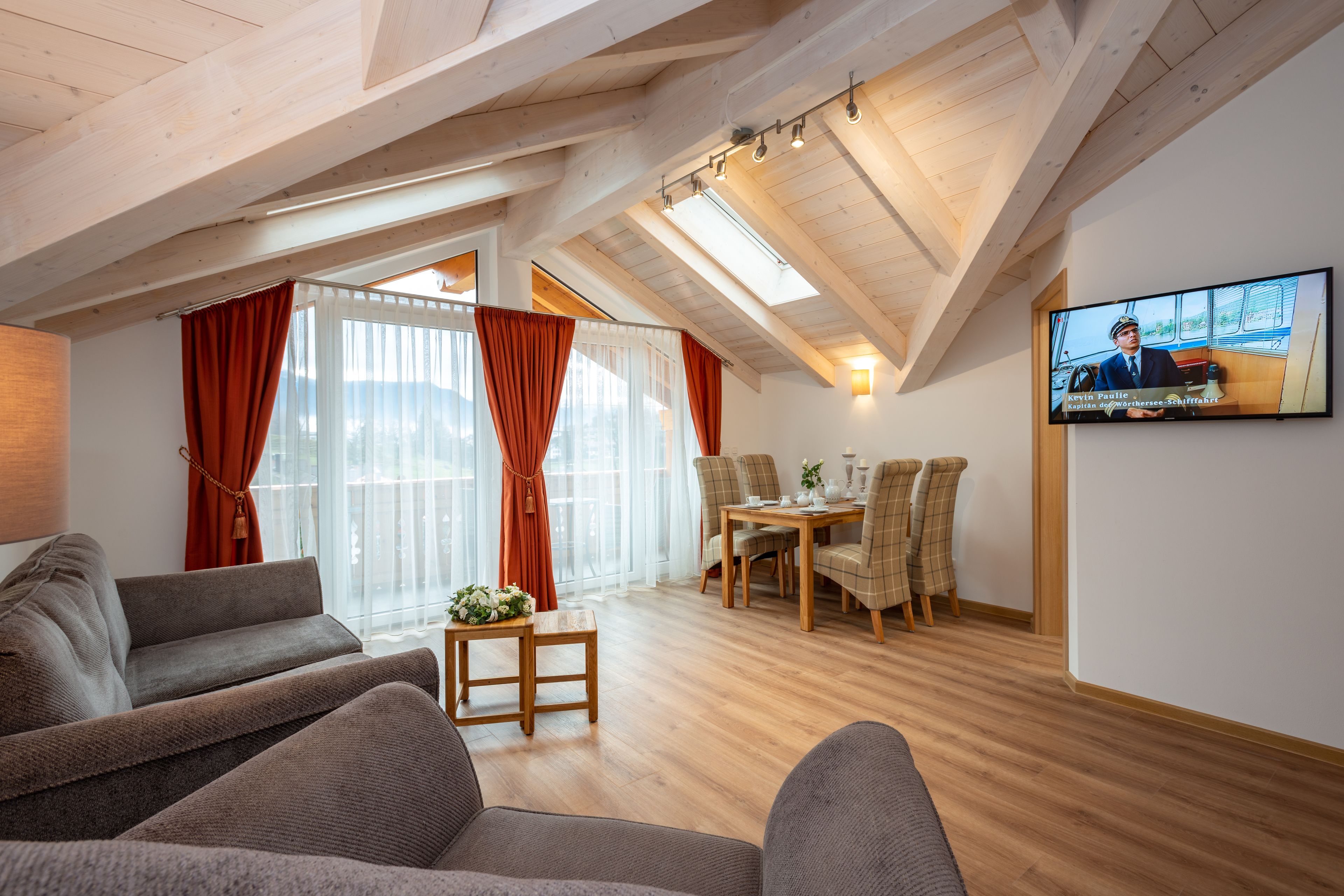 A cozy loft-style room with a dining area, a television, and a sofa.