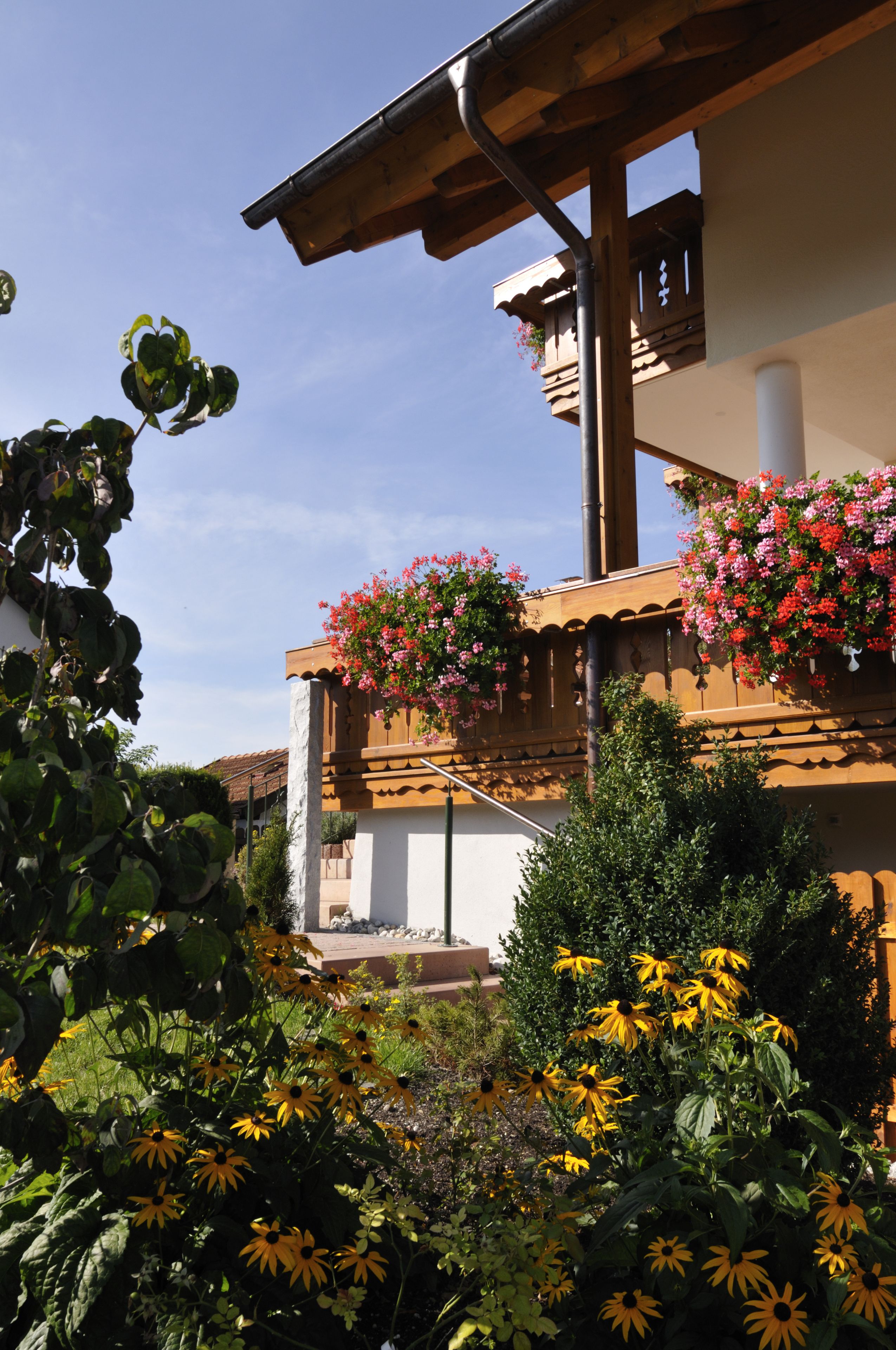 A building with a balcony adorned with hanging flower baskets.