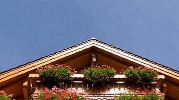 A building with a wooden facade and a balcony with flower boxes.