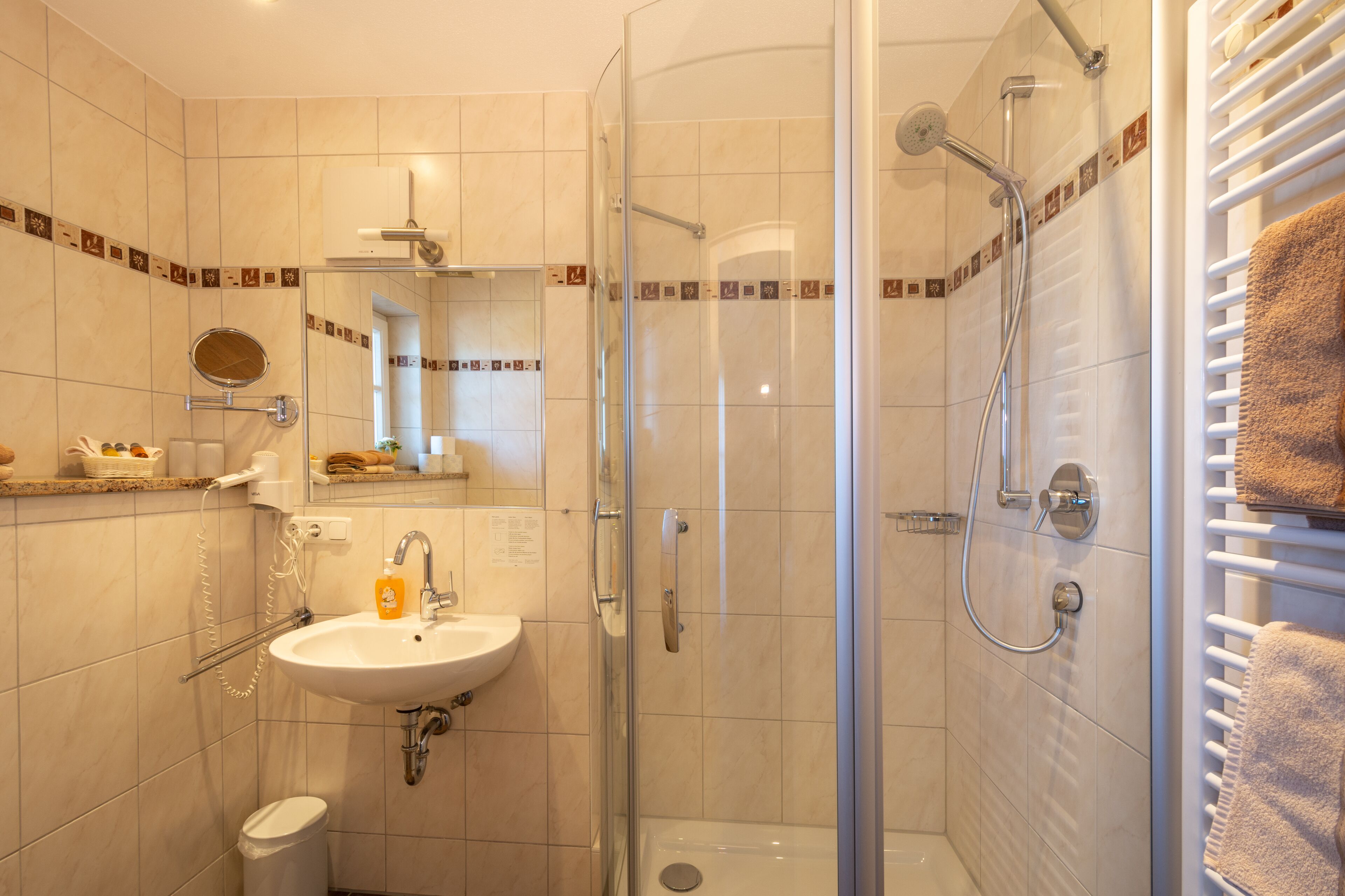 A modern bathroom with a glass-enclosed shower, a sink, and a toilet.