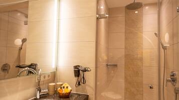 A modern bathroom with a sink, mirror, and shower.