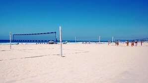 Un terrain de beach-volley avec un filet et des joueurs.