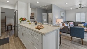Une cuisine moderne dotée d’un plan de travail en marbre, de meubles de rangement intégrés et d’un îlot central.