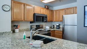 A kitchen with wooden cabinets, a stainless steel refrigerator, a microwave, and a sink. - River Mountain Lodge Colorado Trail Condo: Ski-In, Downtown Breck (Breckenridge)