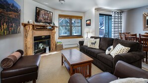 A living room with a fireplace, a sofa, a coffee table, and a television. - River Mountain Lodge Colorado Trail Condo: Ski-In, Downtown Breck (Breckenridge)