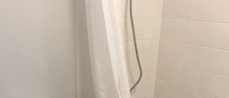 A bathroom with a toilet, a bathtub, and a shower curtain.