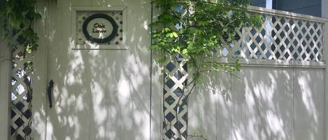 A white wooden gate with a sign that reads "Oak Lawn."